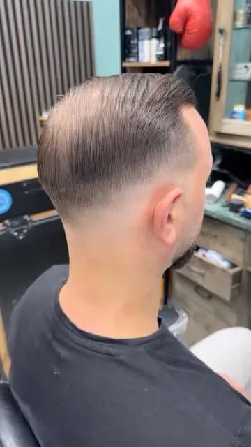 Dégradé à blanc sur la nuque, cheveux coiffés en arrière, vu de dos