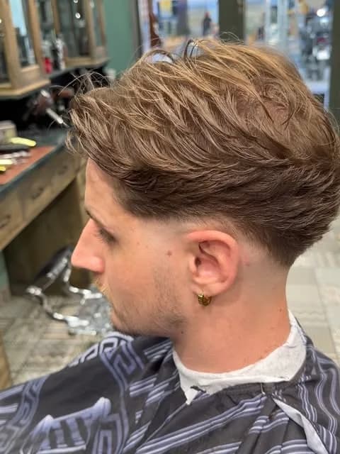 Coupe mi-longue texturée sur le dessus, dégradé bas sur la nuque, vue de profil